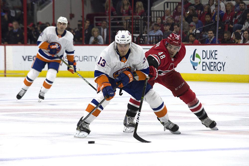 New York Islanders center Mathew Barzal maintains possession of the puck despite pressure from Carolina Hurricanes left wing Jordan Martinook on Thursday, Oct. 4 in PNC Arena. The Hurricanes lost their season home opener against the Islanders 2-1 in overtime.
