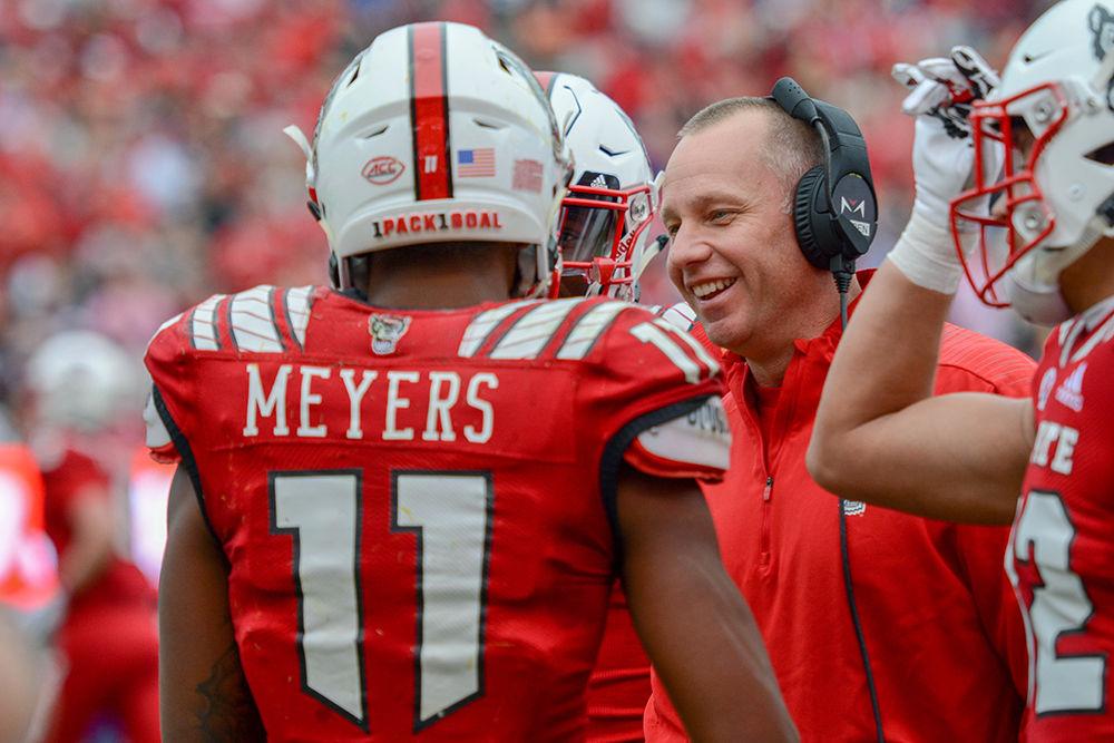 NC State head football coach Dave Doeren celebrates with redshirt junior wide receiver Jakobi Meyers after Meyers broke the NC State record for most yards run in a season on Saturday, Dec. 1 in Carter-Finley Stadium. The Wolfpack beat the Pirates 58-3.