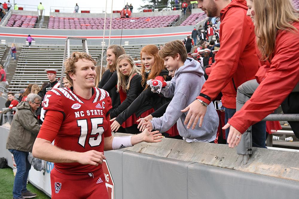 Graduate quarterback Ryan Finley high-fives fans as he exits the field for the last time as an NC State player on Saturday, Dec. 1 at Carter-Finley Stadium. The Pack beat ECU 58-3 in the last home game of the season.