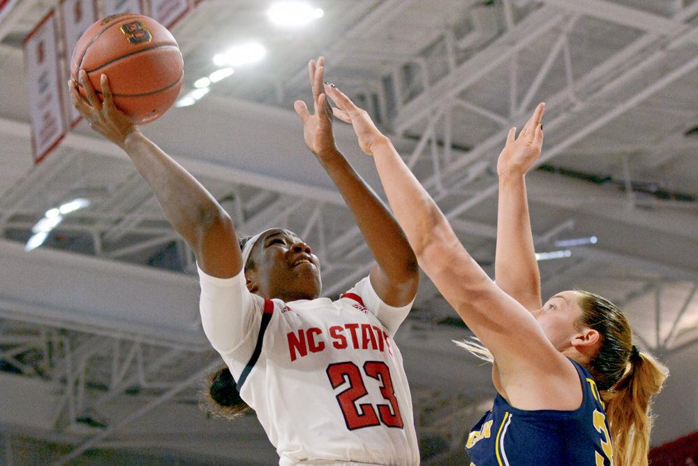 Redshirt junior guard Grace Hunter shoots against Michigan center Hallie Thome on Thursday Nov. 29 in Reynolds Coliseum. Hunter had 19 points, eight rebounds and four steals in the Wolfpack's 66-55 win.