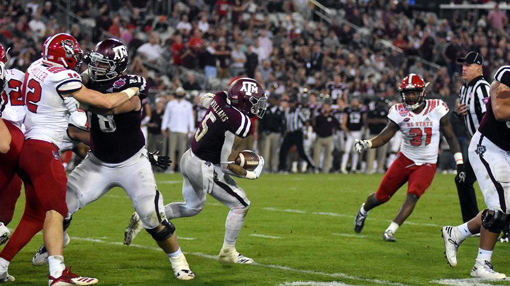 Texas A&amp;M's junior running back Trayveon Williams rushes on Monday, Dec. 31 at the Gator Bowl at TIAA Bank Field in Jacksonville, Florida. Williams broke the stadium's record for longest rushing touchdown with a 93-yard touchdown against the Pack. NC State lost to Texas A&amp;M 52-13.