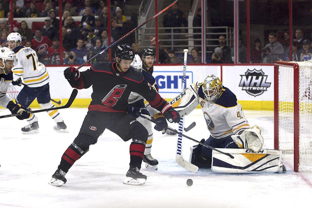 Center Sebastian Aho fights for possession of the puck in front of Buffalo Sabres goalie Carter Hutton in PNC Arena, Friday, Jan. 11. Aho scored twice in the second period, helping the Carolina Hurricanes to win at home, 4-3.