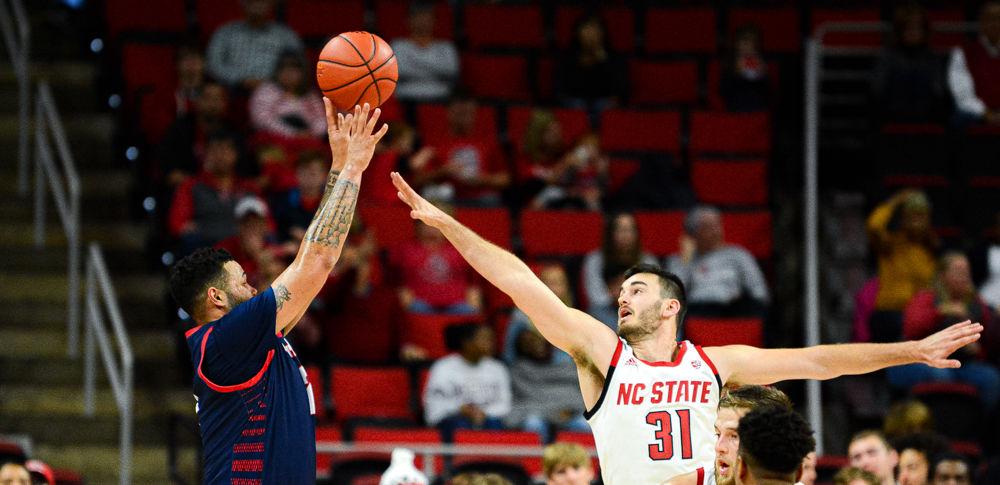 Graduate forward Pat Andree contests a shot by Detroit Mercy forward Justin Miller on Sunday, Nov. 11, 2019 at PNC Arena. Andree scored nine points as the Wolfpack won 84-65.