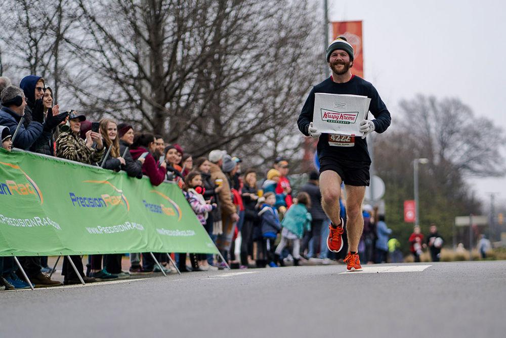 Raleigh area runner Joseph Silvers approaching the finish line of the 2020 Krispy Kreme Challenge with his box Krispy Kreme Doughnuts on Saturday, Feb. 1.