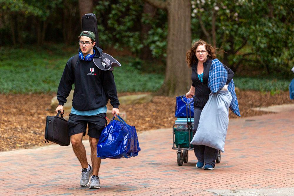 Brodie Nishan, a second year studying zoology, along with his mother move his luggage and essentials to their car during an early move-out for students on Tuesday, March 17, 2020 at Thurman drive. Students were informed earlier on March 17 that the campus would be moving to minimal operations and that dorms would be closing until further notice in an attempt to safeguard against and prevent the spread of the COVID-19 virus. Students have until 5 P.M. on Sunday, March 22, 2020 to take their essentials and return to their permanent residences, with an exception for a few categories of students.