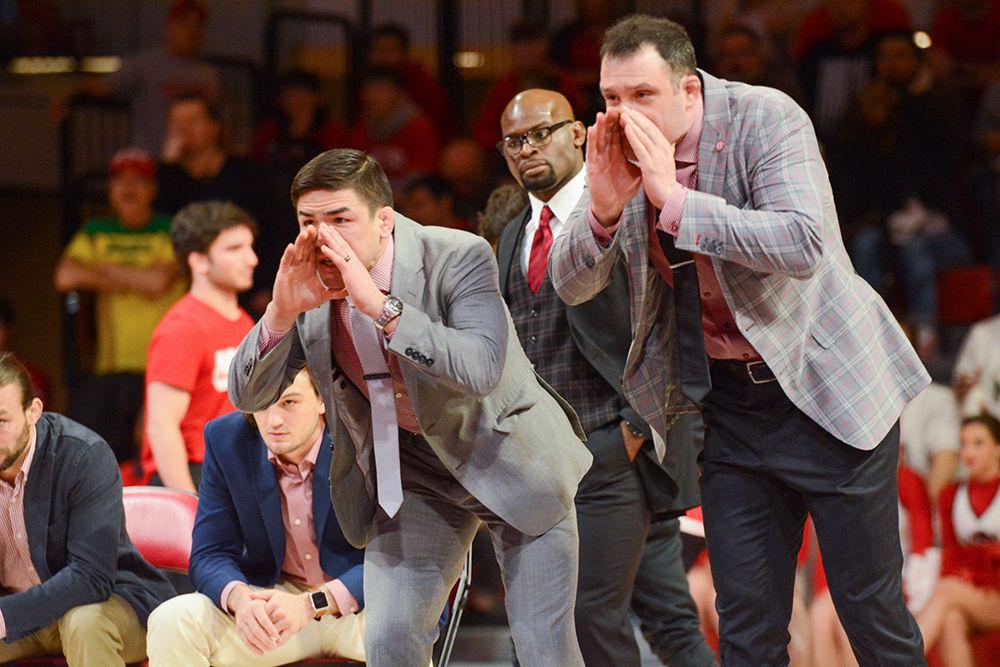 Associate head coach Adam Hall and head coach Pat Popolizio root for the wolfpack at the wrestling match against UNC-CH on Friday, Feb. 7 at Reynolds Coliseum. The wolfpack won the match 19-14 with record fan attendence.