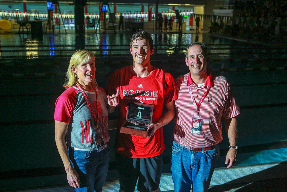 Junior Coleman Stewart poses with Judy and Andy Stewart after being presented with a ring recognizing his achivement as the 2018 100m backstroke national champion. This was one of many rings commemorating national champions during the fourth annual Wolfpack Games held on Friday, Sept. 28 In the Casey Aquatic Center.