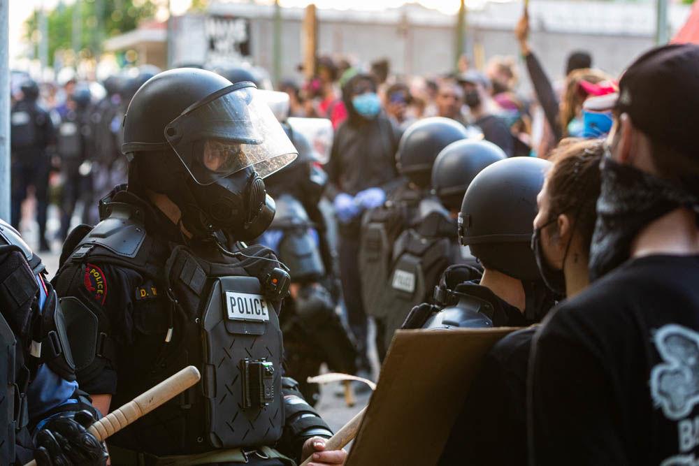 Protesters demonstrate in front of police officers in riot gear on Saturday, May 30, 2020 in downtown Raleigh. The protest was one among many around the United States in response to the death of George Floyd in Minneapolis.