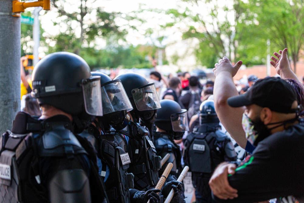 Protesters demonstrate in front of police officers in riot gear on Saturday, May 30, 2020 in downtown Raleigh. The protest was one among many around the United States in response to the death of George Floyd in Minneapolis.