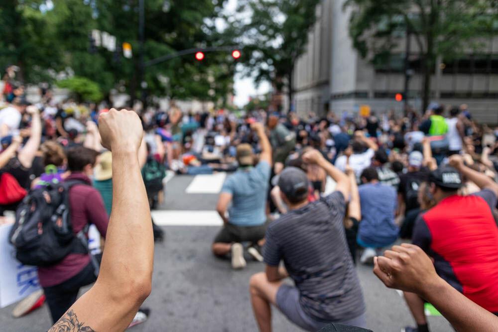 Protesters raise their arms in solidarity during the second day of protests organized by NCBORN on Tuesday, June 2, 2020 in Downtown Raleigh. Protesters performed a die-in protest in front of the capitol building to outline the deaths of individuals through police brutality.
