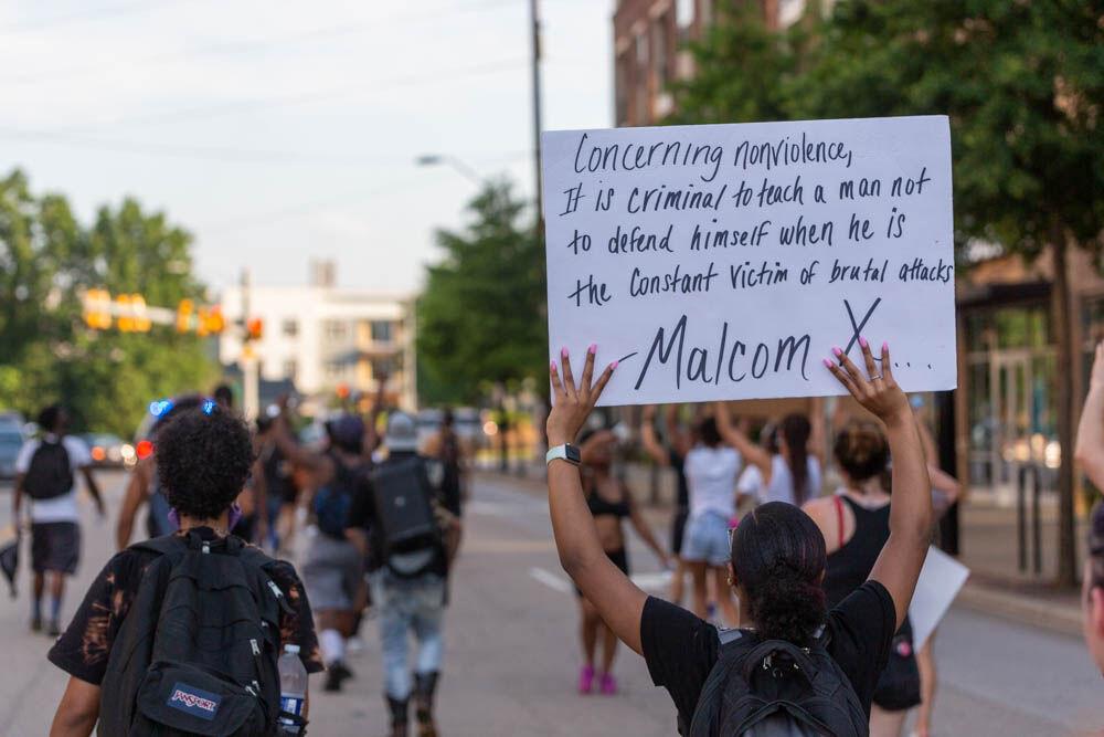 A protester holds up a sign as the march down Oberlin road on Thursday, June 4, 2020 in Cameron Village.