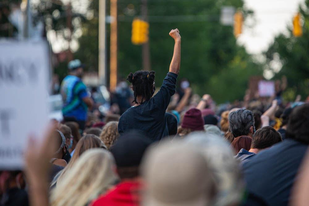 A protester raises her arm up in solidarity while the group took eight minutes and 46 seconds of silence on Tuesday, June 2, 2020 in front of the governors mansion in Downtown Raleigh.