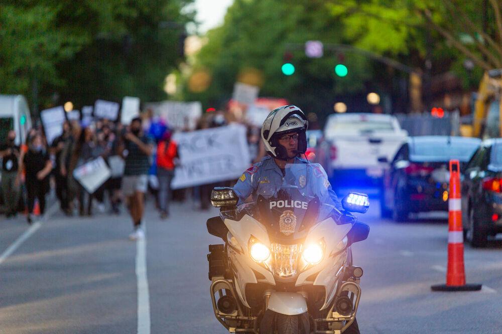 A police officer in front of the protesters, blocking traffic on Hillsborough street to ensure that the protest can go on unhindered on Monday, June 1, 2020 in downtown Raleigh. The Raleigh Police Department consistently assisted in blocking off roads to allow the protesters through in an efficient manner in order to help them protest and get back in time before the beginning of curfew. The mayor of Raleigh issued a city wide curfew until further notice starting from 8 P.M and lasting through 5 A.M. the next morning. The protest on June 1 was completely peaceful through its entirety.