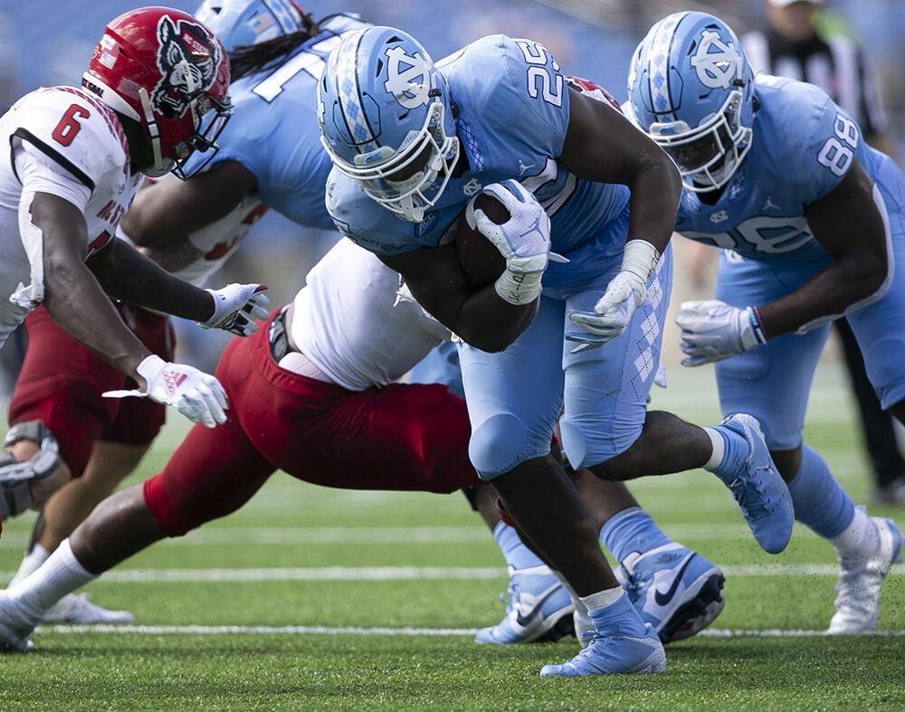 North Carolina's Javonte Williams (25) rushes for a first down in the second quarter against N.C. State at Kenan Stadium on Saturday, October 24, 2020 in Chapel Hill, N.C.