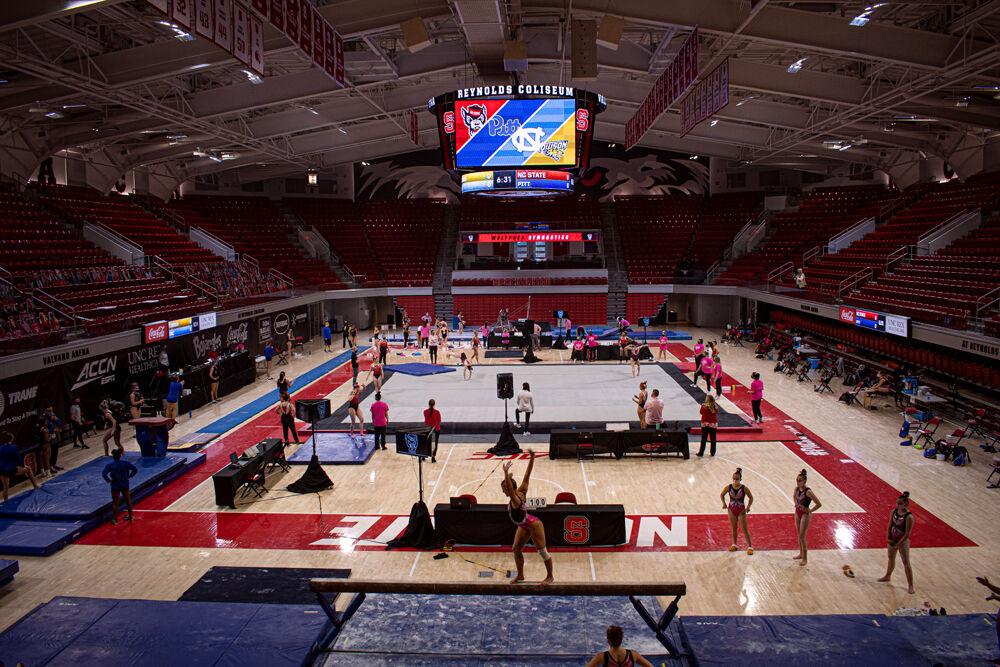 Gymnasts from NC State, Pitt, UNC-Chapel Hill and Towson warm up before the quad meet on Saturday, Feb. 6, 2021 at Reynolds Coliseum. The Wolfpack won the meet with a score of 196.025.
