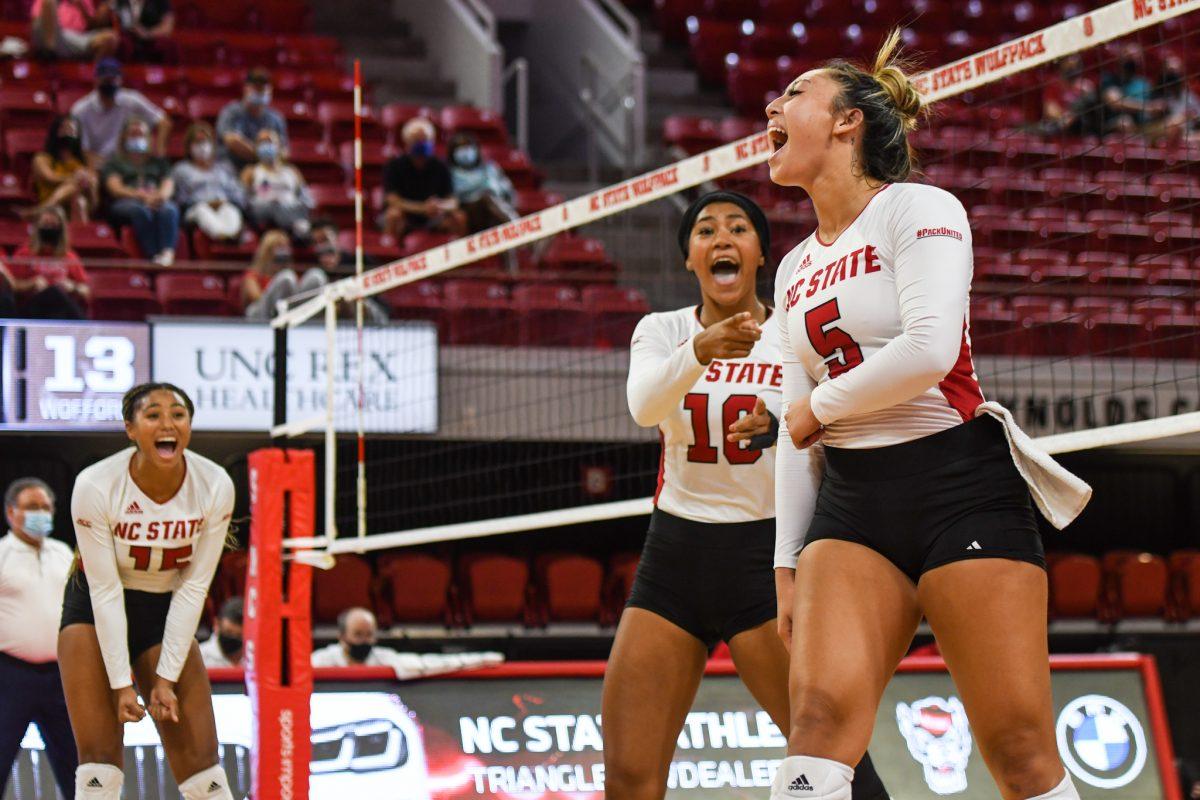 Junior setter Kristen McDaniel celebrates with freshman middle blocker Jada Allen and senior outside hitter Jade Parchment after the Wolfpack scored during the game versus the Wofford Terriers on Friday, Sep. 3, 2021 in Reynolds Coliseum. The Wolfpack beat the Terriers 3-0.