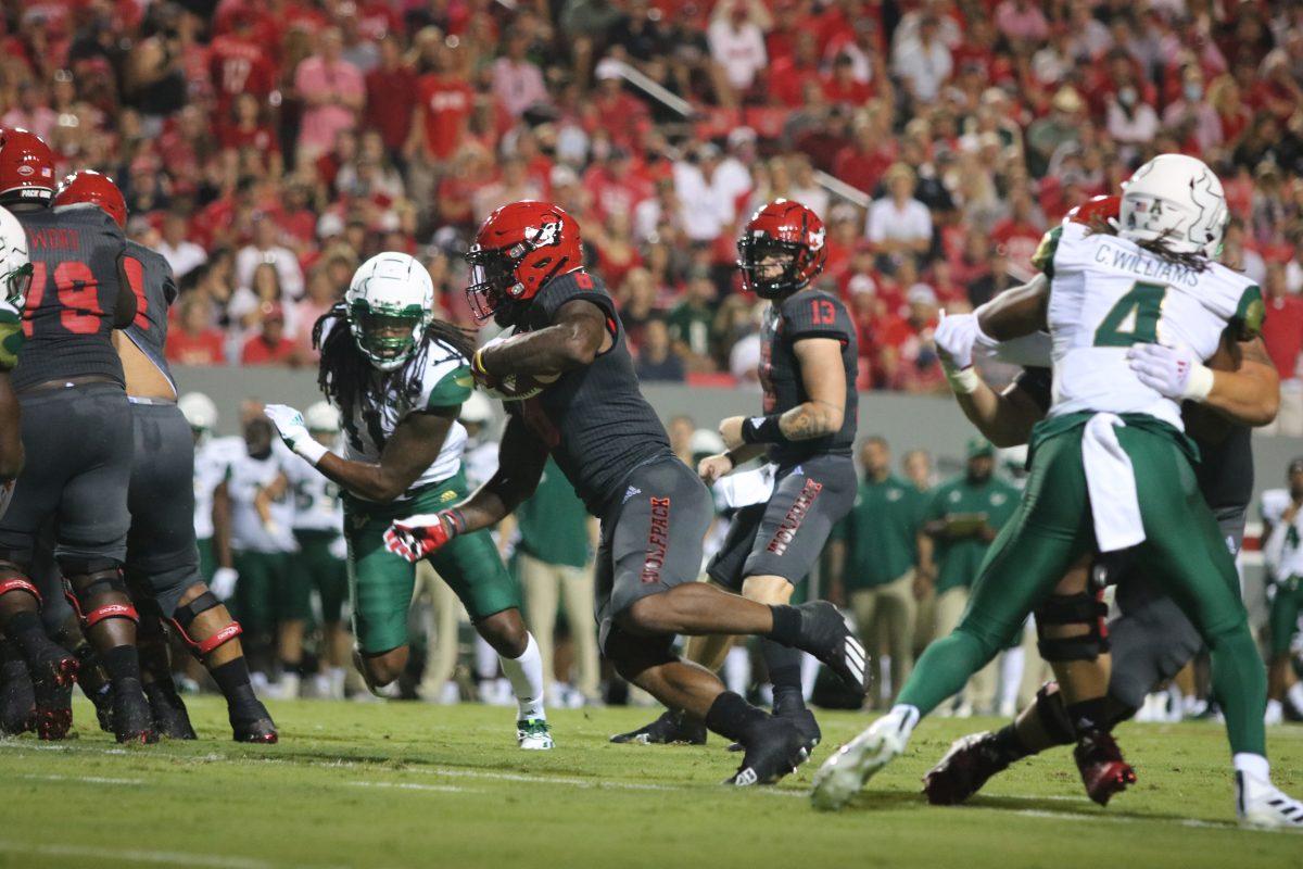 Junior running back Ricky Person Jr. runs the ball down the field during the Wolfpack's game against the South Florida Bulls at Carter-Finley Stadium on Thursday, Sept. 2, 2021. Person had 16 carries totaling 107 rushing yards with two touchdowns. The Wolfpack beat the Bulls 45-0.