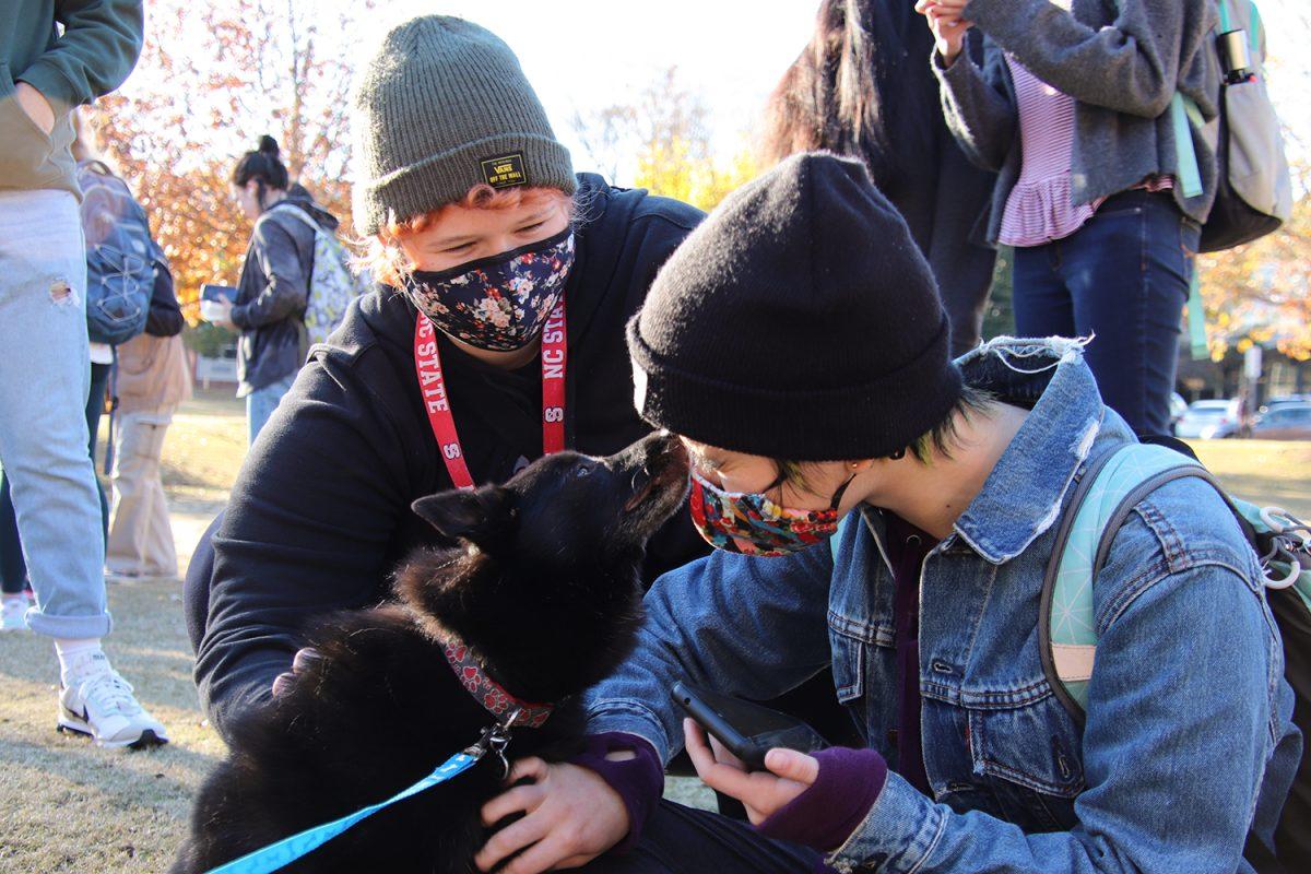 Margo Hankins, a fourth year majoring in zoology and history, and Alyssa Phelps, a fourth year in integrative physiology and neuroscience, enjoys love from Coda during the Puppies and Pizza event at Harris Field on Tuesday, Nov. 30, 2021.