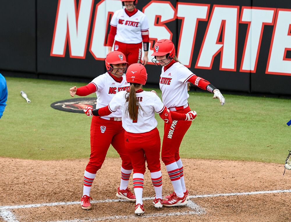 Graduate utility player Taylor Johnson and graduate infielder Randi Farricker prepare to hug graduate outfielder Carson Shaner after she hit a home run in the game against Central Connecticut State on Saturday, Feb. 26, 2022 at Dail Softball Stadium. NC State won the game 13-3.