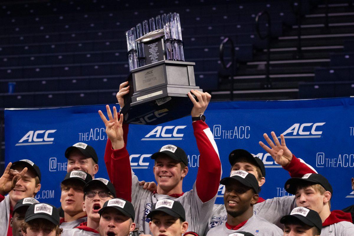Freshman Isaac Trumble hoists NC State wrestling's trophy after winning its fourth-straight ACC title during the 2022 ACC Championships at John Paul Jones Arena in Charlottesville, Virginia on March 6, 2022.