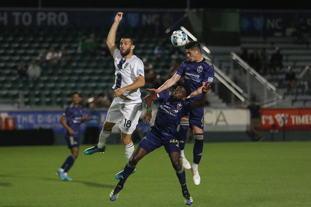 Right-back Gustavo Fernandes heads the ball alongside teammate defensive midfield Raheem Somersall during the game against Greenville Triumph SC on Saturday, April 16, 2022 in Sahlen's Stadium at WakeMed Soccer Park. NCFC and Triumph tied 1-1.