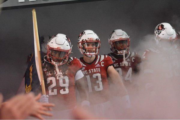 Freshman safety Sean Brown, redshirt sophomore quarterback Devin Leary and redshirt freshman running back Delbert Mimms III emerge from the tunnel at the Homecoming game against Louisville at Carter-Finley Stadium on Saturday, Oct. 30, 2021. Leary threw four touchdowns and led the Wolfpack to a 28-13 victory against the Cardinals.