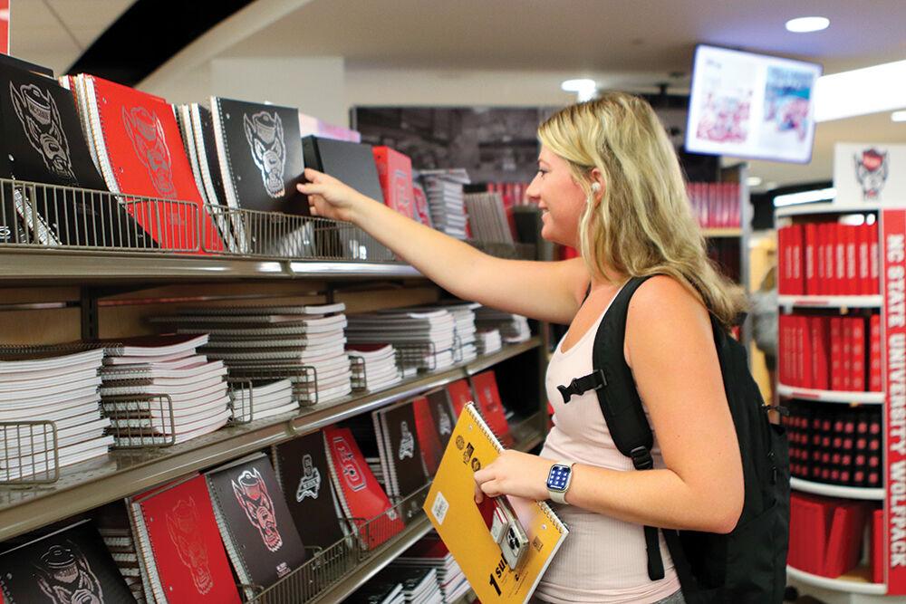 Lilly Barrow, a third-year in business administration, picks up notebooks for classes in Wolfpack Outfitters Bookstore on Monday, Aug. 22, 2022. This was the first day of class for Fall semester.
