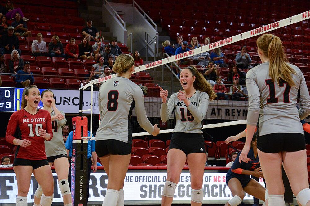 Members of the NC State volleyball team celebrate a score by freshman middle blocker Lily Cropper at the volleyball game against Syracuse on Friday, Oct. 14, 2022 in Reynolds Coliseum. Cropper scored 7.5 points and the Wolfpack defeated the Orange 3-0.