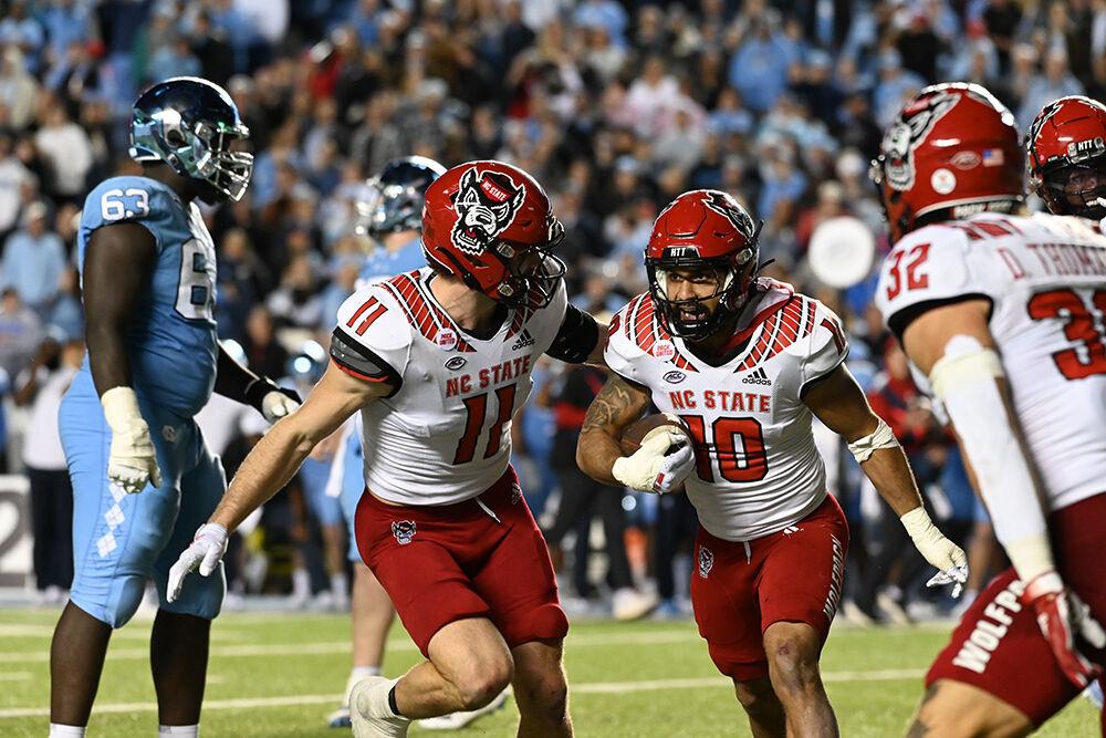 Senior safety Tanner Ingle celebrates with the defense after his interception during the Wolfpack's last regular season football game against the UNC-Chapel Hill Tar Heels at Kenan Memorial Stadium on Friday, Nov. 25, 2022. The Wolfpack beat the Tar Heels in double overtime 30-27.