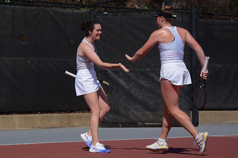 Senior Nell Miller smiles as she high-fives her doubles partner junior Amelia Rajecki during the match against Virginia at the Dail Outdoor Tennis Stadium on Friday, April 14, 2023. The pair won their doubles match 6-3. The Wolfpack beat the Cavaliers 5-2.