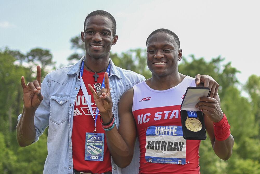 Hurdle coach Reuben McCoy and graduate sprinter Cameron Murray hold up "wolfies" during the outdoor track ACC championships at the&#160;Paul Derr Track and Field Facility on Saturday, May 13, 2023. Murray came in first place for the 110m hurdles.