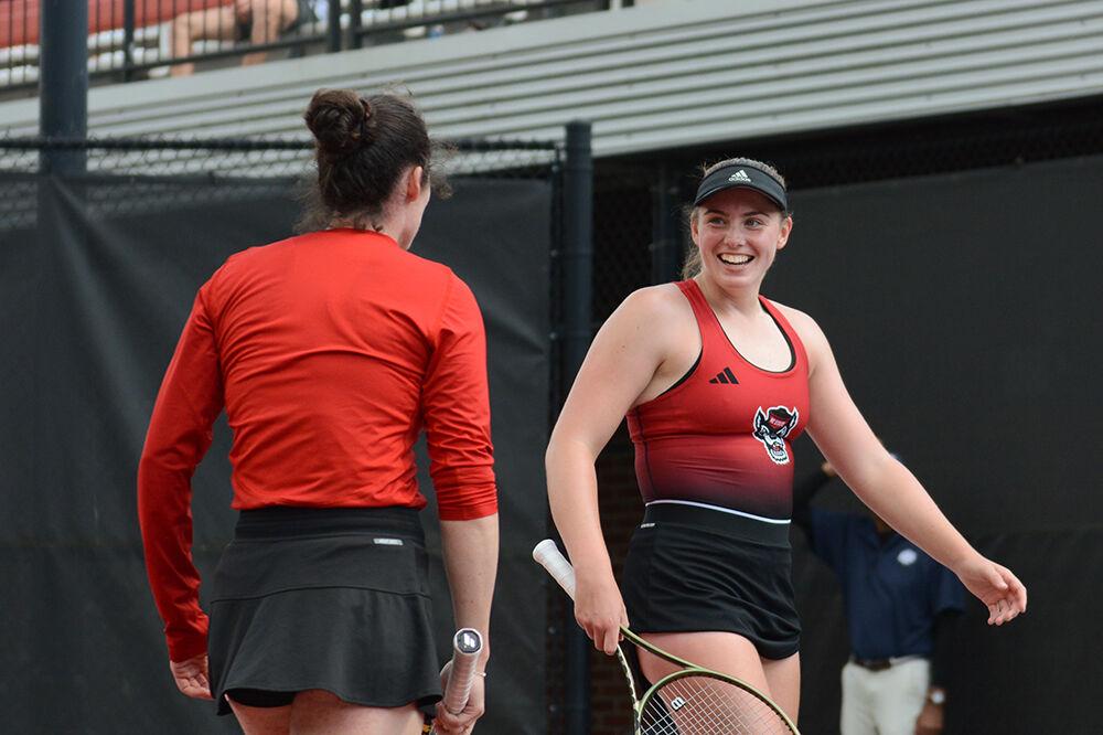 Junior Amelia Rajecki (right) laughs as she talks to her doubles partner fifth-year Nell Miller (left) during the match against Kansas at Dail Outdoor Tennis Stadium on Saturday, May 6, 2023. The pair won their doubles match 6-2. The Wolfpack defeated the Jayhawks 4-0.