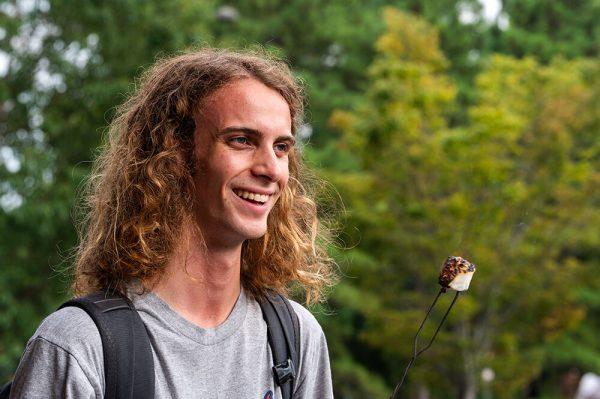 Jack Fulp, a first-year studying environmental technology and management, roasts a marshmallow during the S'mores by the Campfire event outside Carmichael Gym on Tuesday, Aug. 22, 2023. This event was hosted by Outdoor Adventures as a part of Wolfpack Welcome Week.