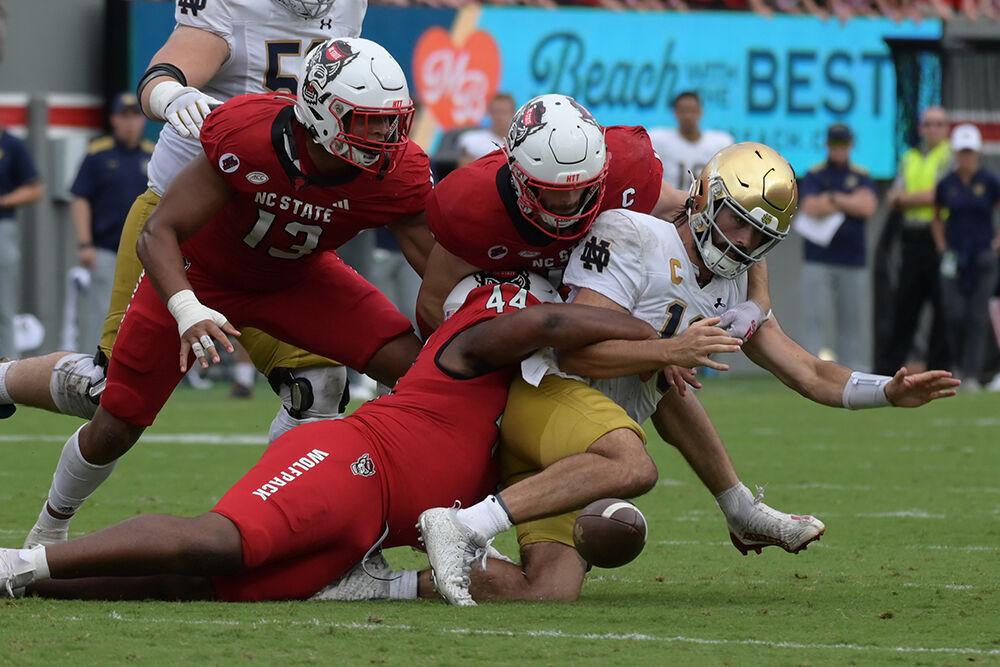 Sophomore defensive lineman Brandon Cleveland strips Notre Dame quarterback Sam Hartman of the ball resulting in a fumble recovery for NC State during the Wolfpack's home opener against the Notre Dame Fighting Irish in Carter-Finely Stadium on Saturday, Sept. 9, 2023. After a severe rain delay, the Irish defeated the Wolfpack 45-24.