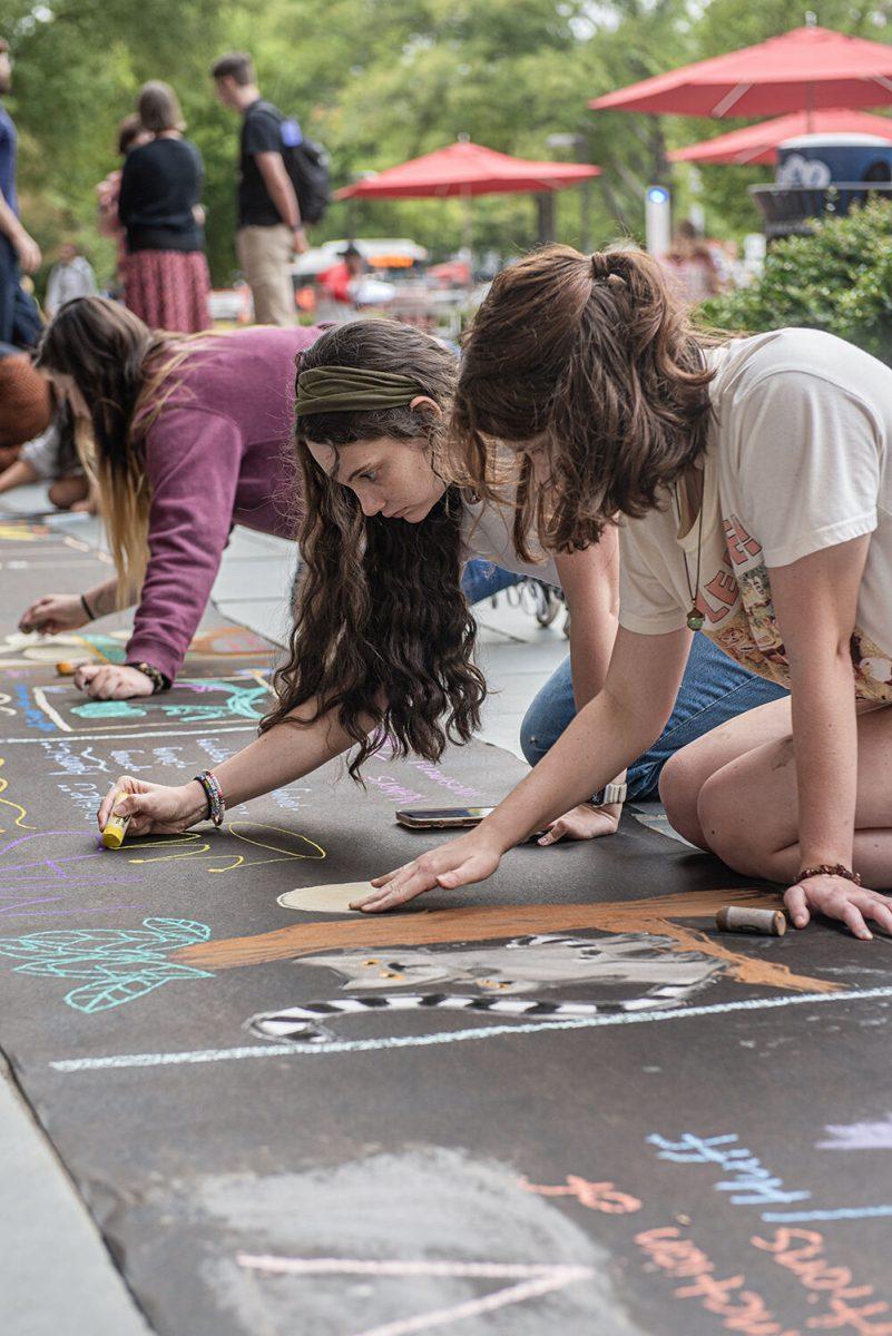 Maddie Greenway, a fourth-year studying zoology, and Hallie Gooch, a third-year studying biology, illustrate their research at the Sidewalk Symposium in front of D.H. Hill Jr. Library on Tuesday, Sept. 26, 2023. The event was hosted by the Office of Undergraduate Research, who selected students to participate in presenting their work.