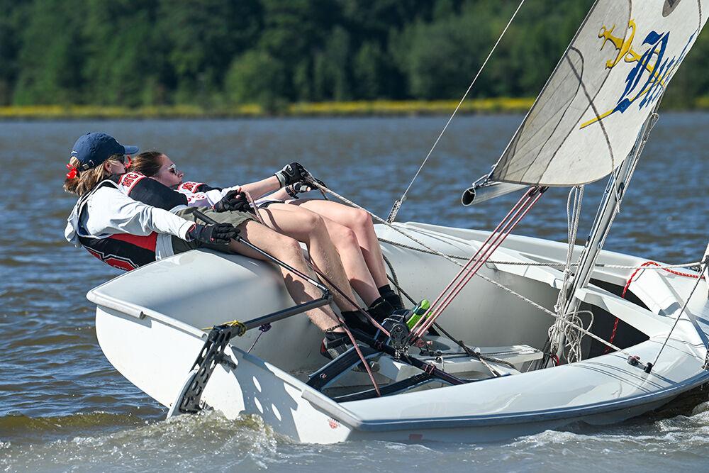 Maddison Carew, a first-year studying industrial design, and Annika Milstien, a third-year studying mechanical engineering, lean out of the boat to create momentum during practice at Lake Crabtree County Park on Friday, Sept. 15, 2023.
