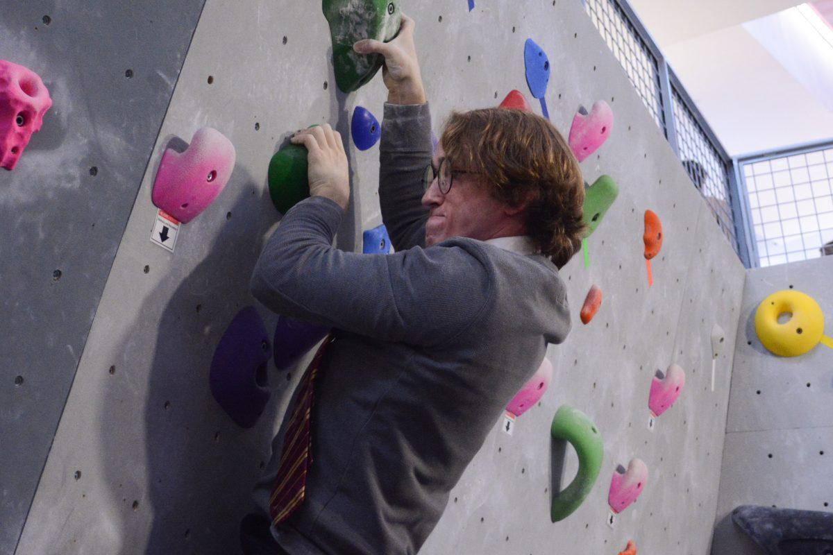 David Greenwell, a graduate student in electrical engineering, winces as he climbs during the Boulder Bash at Carmichael Gymnasium on Sunday, Oct. 29, 2023. Greenwell was dressed as Harry Potter, as participants were encouraged to dress up in Halloween costumes for a contest following the Bash.