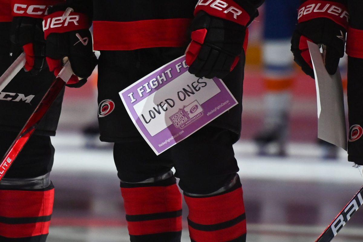 Carolina Hurricanes center Jack Drury holds a Hockey Fights Cancer page before the game against the New York Islanders on Thursday, Nov. 30, 2023. The Hurricanes all held signs stating a person or loved one that they were fighting for. The Islanders beat the Hurricanes 5-4 in overtime.