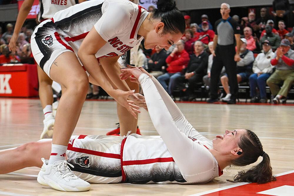 Graduate forward Mimi Collins (left) helps up graduate center River Baldwin (right) in the game against Florida State inside Reynolds Coliseum on Thursday, Jan. 4, 2023. The Wolfpack beat the Seminoles 88-80.