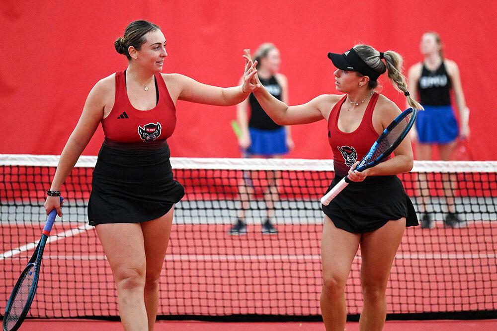 Senior Abigail Rencheli and freshman Gabriella Broadfoot high-five after scoring a point during the match against SMU at J.W. Isenhour Tennis Center on Monday, Jan. 15, 2024. Rencheli and Broadfoot won the doubles match 6-1. NC State defeated SMU 7-0.