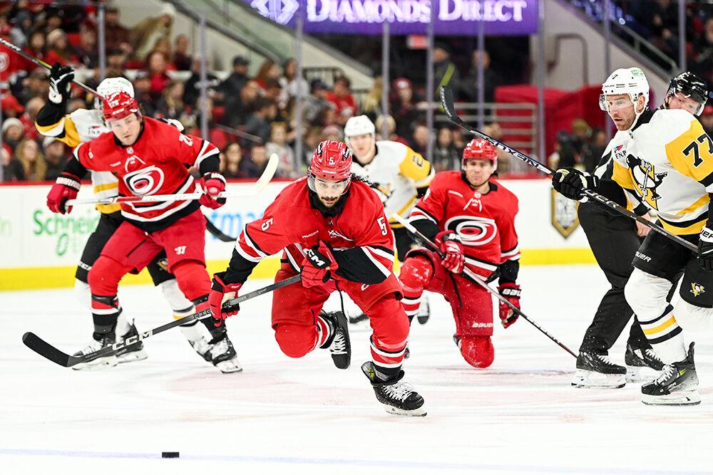 Carolina Hurricanes defenseman Jalen Chatfield races after the puck during the game against the Pittsburgh Penguins in PNC Arena on Saturday, Jan. 13, 2024. Chatfield made one assist. The Hurricanes beat the Penguins 3-2 in overtime.