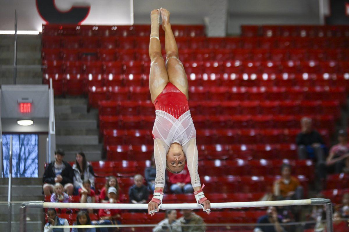 Junior Payton Childs rotates herself while on the bar during the meet against UNC-Chapel Hill in Reynolds Coliseum on Sunday, Feb. 11, 2024. Childs scored a 9.800 average in the uneven bars event. NC State beat UNC 196.725-194.925