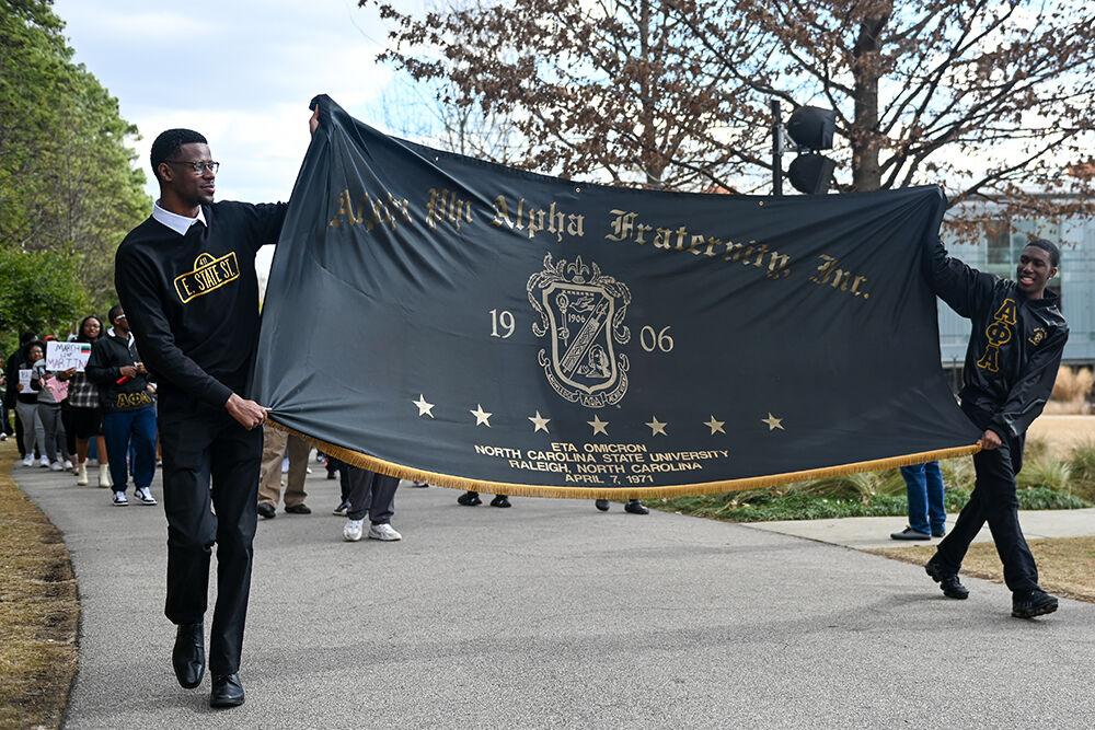 Ethan Robinson, a fourth-year studying sport management, and Kaleb Hall, a third-year studying communications, carry the Eta Omicron chapter of Alpha Phi Alpha Fraternity flag while leading the March Like Martin event from Stafford Commons to Harris Field on Friday, Jan. 19, 2024. The Alpha Phi Alpha's led the march to honor Martin Luther King Jr. as he was also a member of the fraternity.