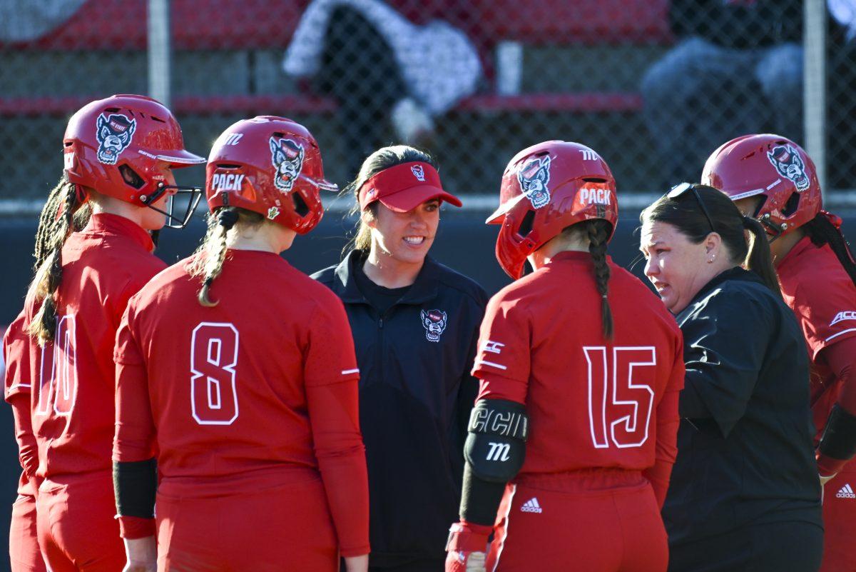NC State softball assistant coach Grayson Radcliffe and head coach Lindsay Leftwich talks to the team during the game against App State at Dail Softball Stadium on Sunday, Feb. 25, 2024. NC State beat App State 6-2.