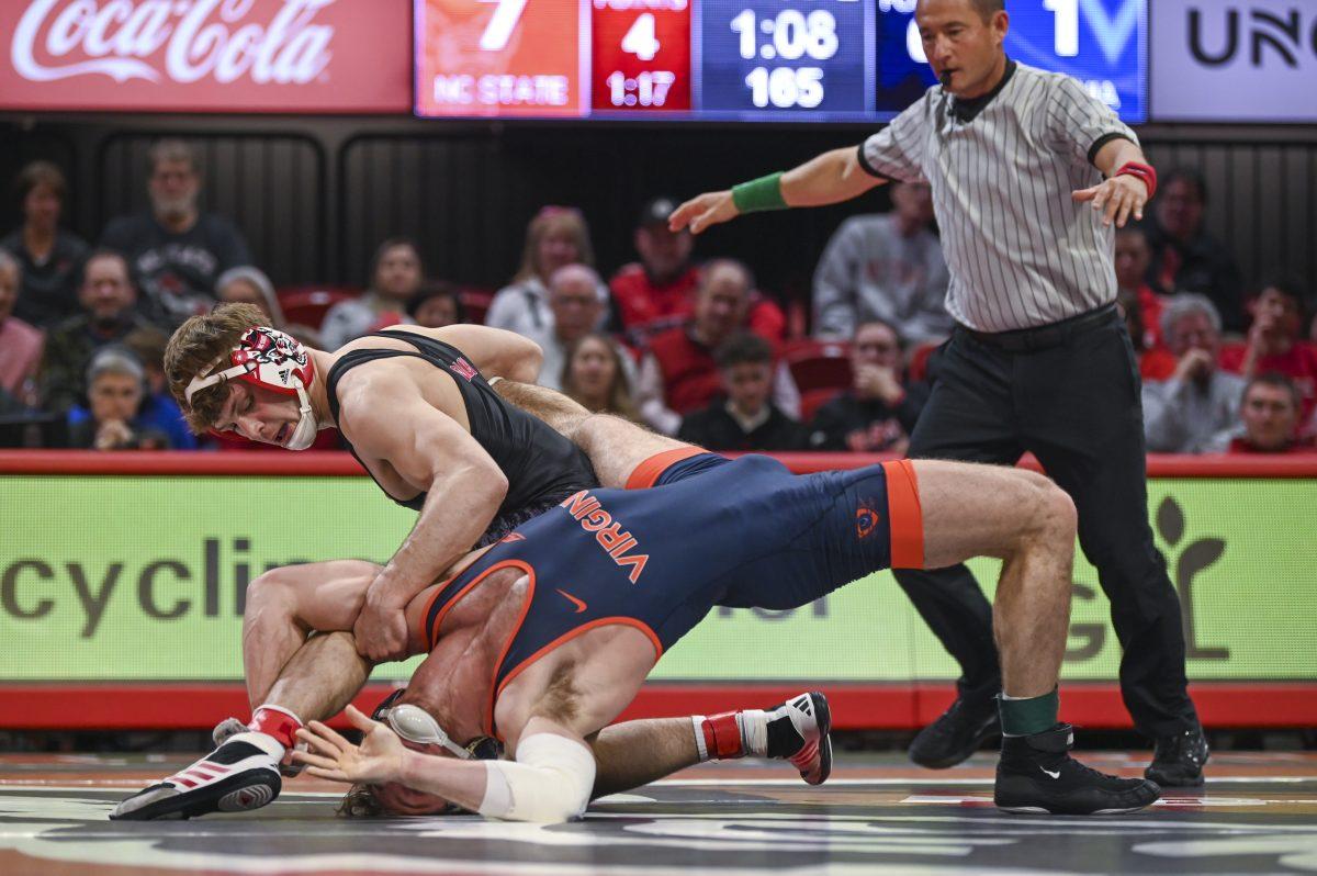 Redshirt sophomore Derek Fields restrains his opponent during the wrestling match against the University of Virginia in Reynolds Coliseum on Friday, Feb. 9, 2024. Jack won the 165 bout 11-7. NC State beat UVA 38-3