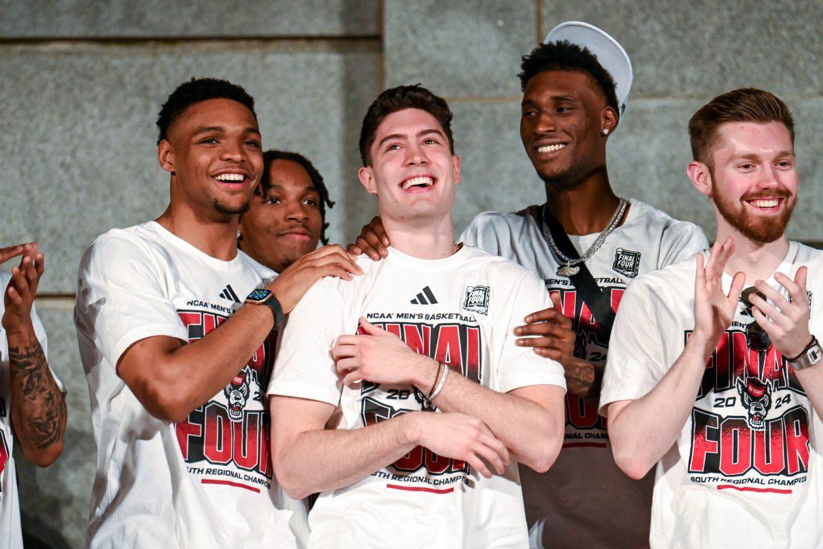 The team grabs graduate guard Michael O'Connell as the Raleigh mayor talks about his three-pointer against Virginia in the ACC Tournament semifinal game during the men's and women's basketball Final Four celebration at the Belltower on Monday, April 15, 2024. Mayor Mary-Ann Baldwin declared April 15 "NC State University Men's and Women's Basketball Day" in the city of Raleigh.