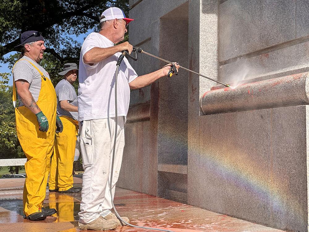 Work crews clean up graffiti spray-painted on the Memorial Belltower on Tuesday, May 28, 2024. Pro-Palestinian messages were spray-painted on the base and plaza, along with red paint to symbolize blood. NC State Police are investigating.