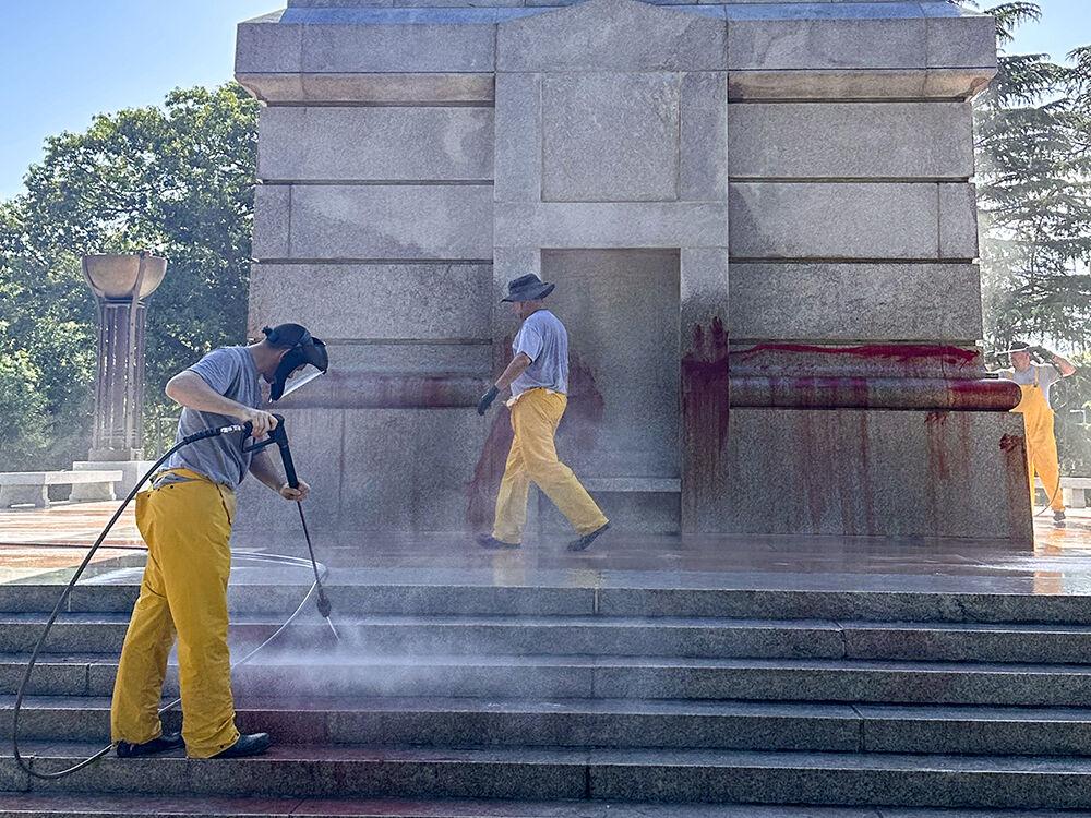 Work crews clean up graffiti spray-painted on the Memorial Belltower on Tuesday, May 28, 2024. Pro-Palestinian messages were spray-painted on the base and plaza, along with red paint to symbolize blood. NC State Police are investigating.