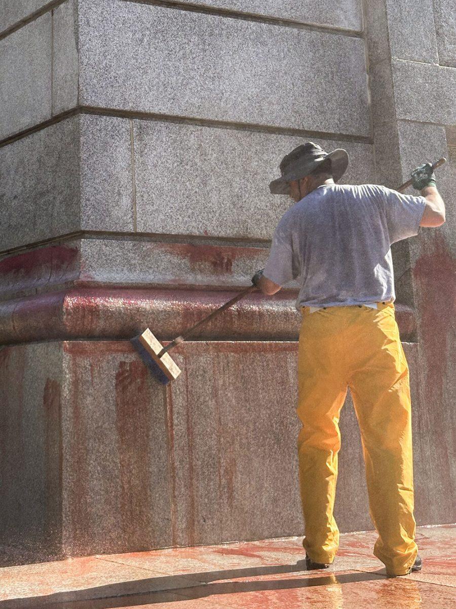 Work crews clean up graffiti spray-painted on the Memorial Belltower on Tuesday, May 28, 2024. Pro-Palestinian messages were spray-painted on the base and plaza, along with red paint to symbolize blood. NC State Police are investigating.