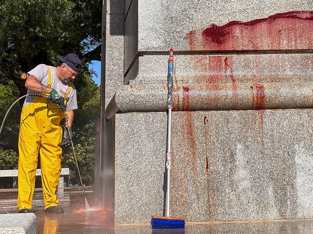 Work crews clean up graffiti spray-painted on the Memorial Belltower on Tuesday, May 28, 2024. Pro-Palestinian messages were spray-painted on the base and plaza, along with red paint to symbolize blood. NC State Police are investigating.
